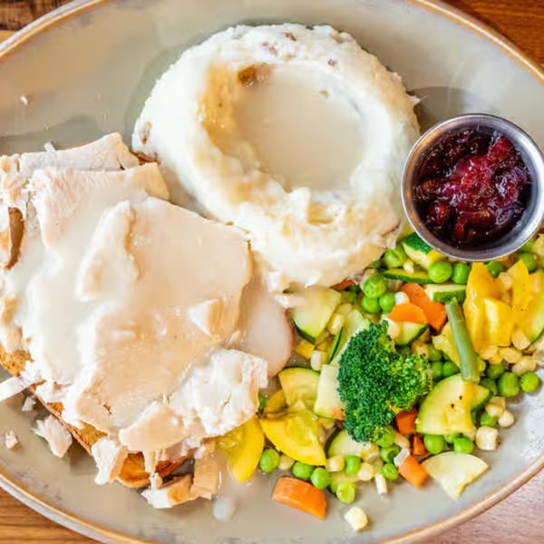 Castle Cafe's open-faced turkey sandwich with mashed potatoes, gravy, mixed vegetables, and cranberry sauce.